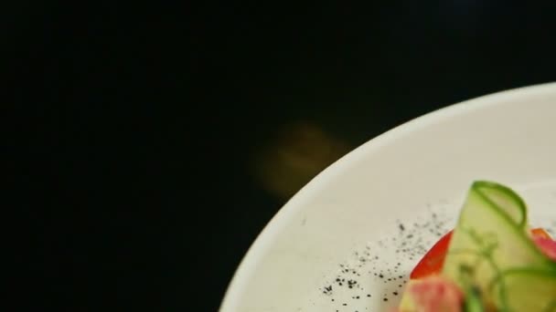 Крупним планом дрібно прикрашена ресторанна тарілка, одягнена на чорний стіл — стокове відео