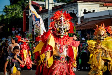 Concepcion De La Vega, DOMINICAN REPUBLIC - FEBRUARY 09, 2020: many people in flamboyant costumes pass by city street at dominican carnival on February 9 in Concepcion De La Vega