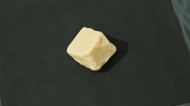 top view on female hand takes away and puts big cube of white marzipan mass
