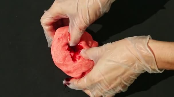 Верхний вид крупным планом женские руки добавить красный краситель в розовый марципан массы и месить его — стоковое видео