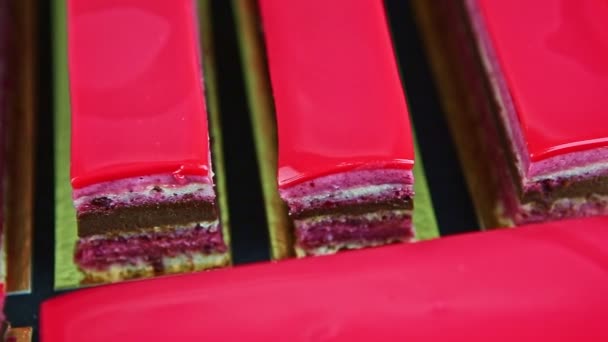 Slowly closeup panorama at portions of pink glazed chocolate and berry layered cake — Wideo stockowe