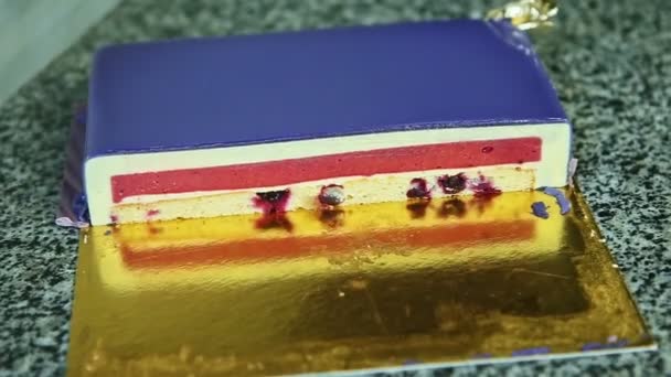 Focus in at half of violet glazed cheesecake with red jelly interlayer and cherries — Stockvideo