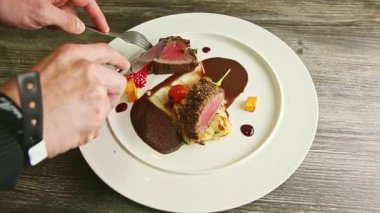 İnsan eli, çatal ve bıçakla kavrulmuş etten küçük dilimler koparır.