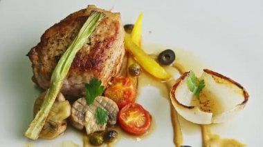 Sosla ve sebzeyle süslenmiş kızarmış et manzarası