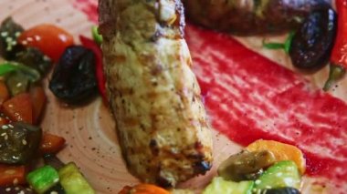 Kızarmış kaburga ve ızgara sebzeler pembe tabakta döner.