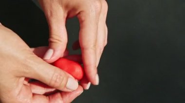 Üst görünüm yakın çekim elleri küçük bir parça kırmızı badem ezmesinden oluşan bir kalp oluşturur.