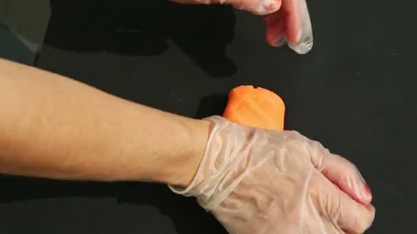 Bovenaanzicht Mensenhanden Handschoenen Kneed Groot Stuk Oranje Marsepein Massa — Stockvideo