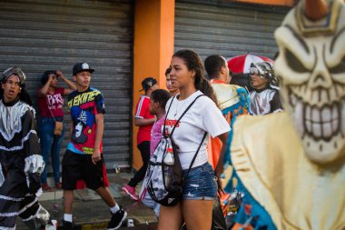 Concepcion De La Vega, DOMINICAN REUBLIC - 11 Şubat 2019: Gençler 11 Şubat 'ta Concepcion De La Vega' da Dominik Karnavalı 'nda sokak sokak tropik yağmurlar altında yürüyor