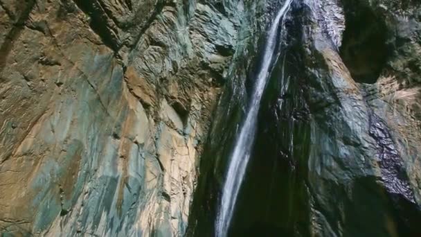 Панорама на сильному гірському водоспаді в оточенні високих скель — стокове відео