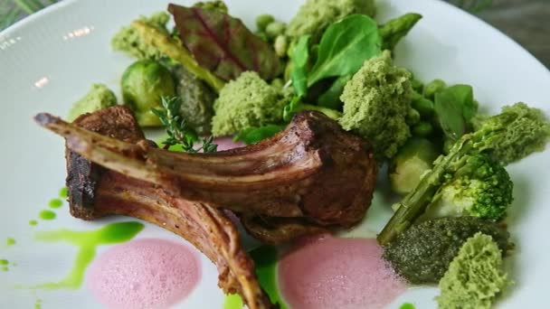 Közelkép zoom ki a modernül berendezett nagy grillezett bordák zöld zöldségekkel — Stock videók