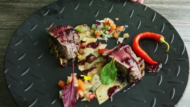 Rota el plato negro con trozos de carne frita, papas fritas y ensalada de verduras — Vídeos de Stock