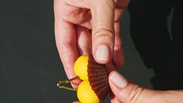 Nahaufnahme weibliche Hände zeigen doppelte Marzipan-Bonbons in Kirschform — Stockvideo