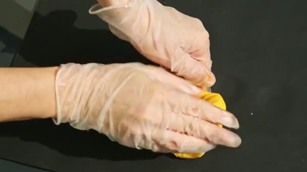 Вид зверху на людські руки в рукавичках замішав великий шматок жовтого марципанової маси — стокове відео