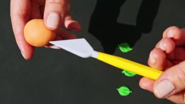 Kadın eli ile şeftali şekilli badem ezmesi şekeri yapma sürecinin üst görünümü