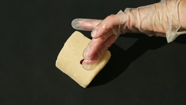 Vue du dessus sur les mains de la femme mettre du colorant rouge sur un gros cube de pâte d'amande blanche — Video
