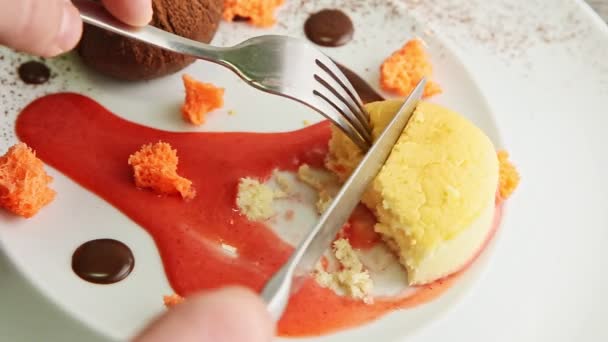 Primer plano manos humanas corte postre cupcake amarillo por tenedor y cuchillo — Vídeo de stock