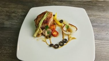 Sos ve sebzelerle süslenmiş kızarmış ete yavaşça zum yap.