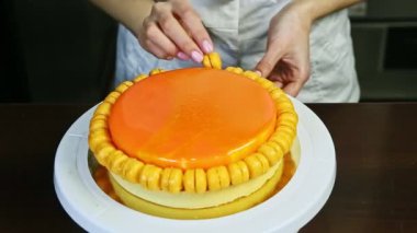 Küçük sarı badem kurabiyeleriyle turuncu kaplı yuvarlak peynirli pastacı.