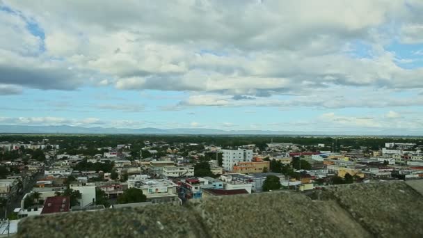 Langzaam panorama op kleine stad tegen pluizige witte wolken boven blauwe bergen — Stockvideo
