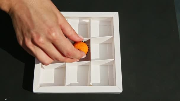 Πάνω όψη στο γυναικείο χέρι βάζει φρούτα σχήμα καραμέλα marzipan σε λευκό κουτί δώρου — Αρχείο Βίντεο