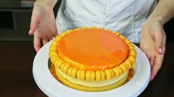 Pasticceria ruota stand filatura bianca con torta di formaggio rotondo smaltato arancione — Video Stock