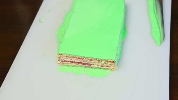 Вид сверху на срезанный сливочный фруктовый слоистый торт с зеленым зеркалом глазури — стоковое видео