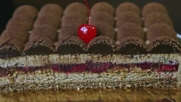 Közelkép fele a modern alakú csokoládé torta forog körül arany stand — Stock videók