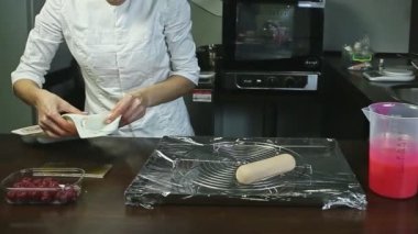 Şekerci, donmuş oval pasta formlarını çıkarıp metal standına koyuyor.