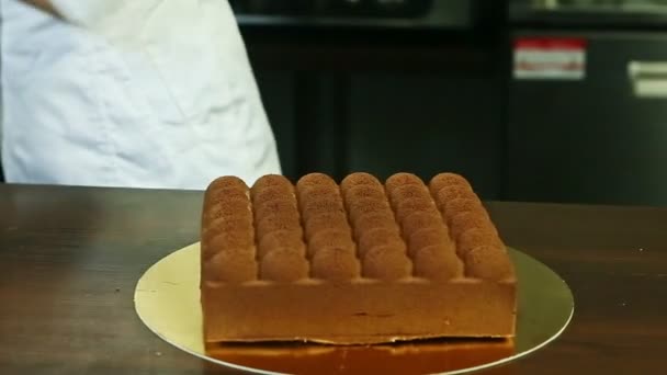 Confiseur en uniforme de chef passer par gâteau à la crème au chocolat en forme originale — Video