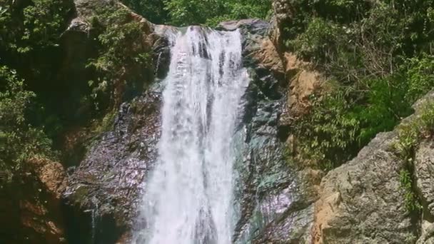 panorama rapproché à forte cascade de montagne entourée de grosses pierres 