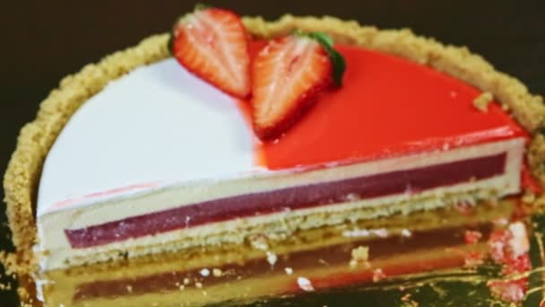 Mise au point à la moitié du gâteau au fromage rond avec intercalaire de gelée rouge et glaçage coloré — Video