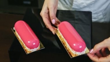 Elle şekerlemeci pembe camlı oval eklerleri hindistan cevizi talaşıyla süslüyor.