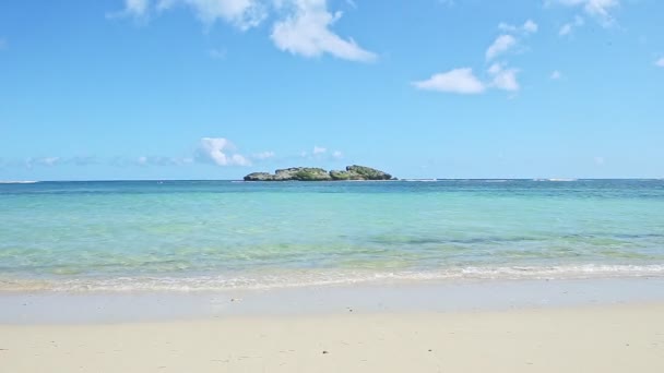 nuages blancs pelucheux au-dessus de l'océan bleu avec vagues et plage de sable doré 