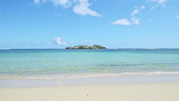 Nuages blancs pelucheux au-dessus de l'océan bleu avec vagues et plage de sable doré — Video