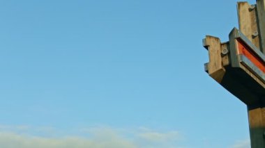 Gün batımında mavi gökyüzüne karşı büyük metal haçta yavaşça panorama kapanışı
