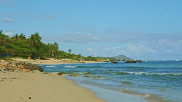Nuages blancs pelucheux au-dessus de l'océan bleu avec vagues et plage de sable doré — Video