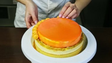 Küçük sarı badem kurabiyeleriyle turuncu kaplı yuvarlak peynirli pastacı.