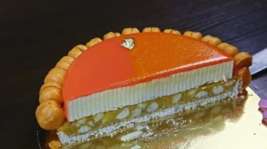 Bıçakla şekerlemeci portakallı cheesecake 'in yarısını iç katmanda yemeye çalışıyor.