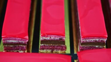 Üst manzara, birçok porsiyon pembe jöleli kremalı meyveli pasta.