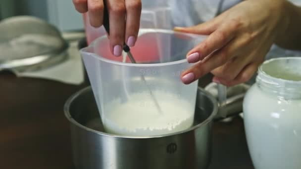 Closeup confectioner hands slowly stir white whipped cream in big plastic pail — Stock Video