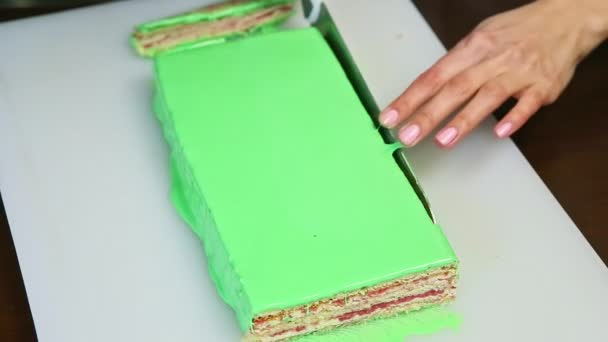 Vue de dessus sur les mains coupées au couteau un bord de gâteau crème glacée verte — Video