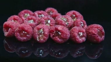 Jöleli taze ahududu grubu siyah arka planda uzanıyor.