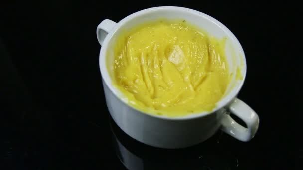 Primo piano messa a fuoco fuori dalla crema gialla servita in tazza bianca — Video Stock