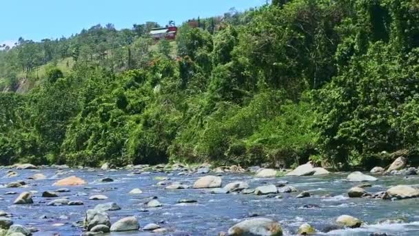 Powoli panorama szerokiego górskiego potoku rzecznego z kamiennymi rzekami przeciwko lasowi — Wideo stockowe