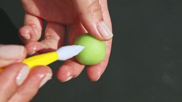 Vista superior en manos humanas haciendo caramelos en forma de manzana de masa de mazapán verde — Vídeos de Stock
