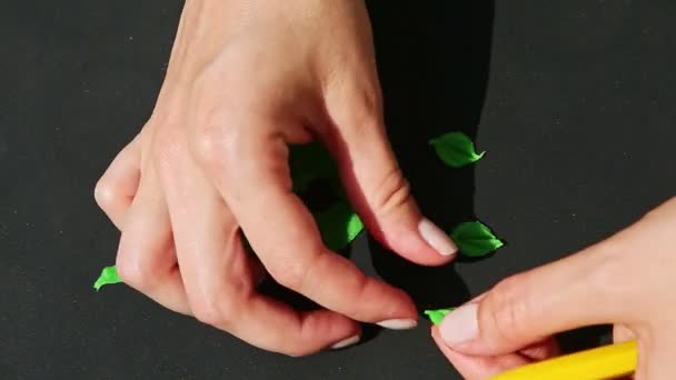 Bovenaanzicht op vrouwenhanden die kleine bladvormen maken van groene marsepeinmassa — Stockvideo