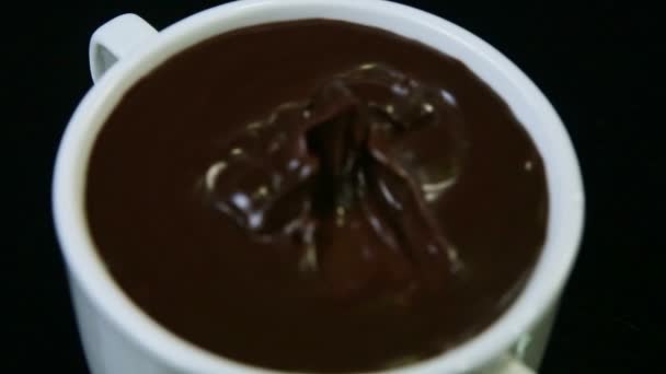 Top view closeup focus in on melted dark chocolate served in white round cup — Stock Video