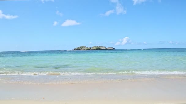 Nuages blancs pelucheux au-dessus de l'océan bleu avec vagues et plage de sable doré — Video