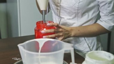 Karıştırıcı tarafından dövülen şekerlemeci büyük plastik kovada ev yapımı sıvı jöle