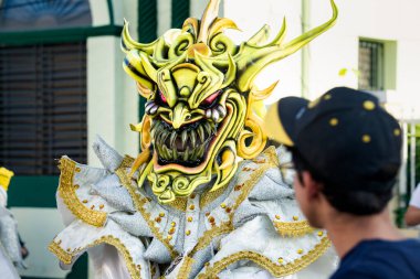 Concepcion De La Vega, DOMINICAN REPUBLIC - FEBRUARY 09, 2020: Parlak karnaval kostümlü adam 9 Şubat 'ta Concepcion De La Vega' da Dominik şehir caddesinde fotoğraf için poz verdi